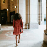 Black Female walking with Asos dress and Valentino shoes